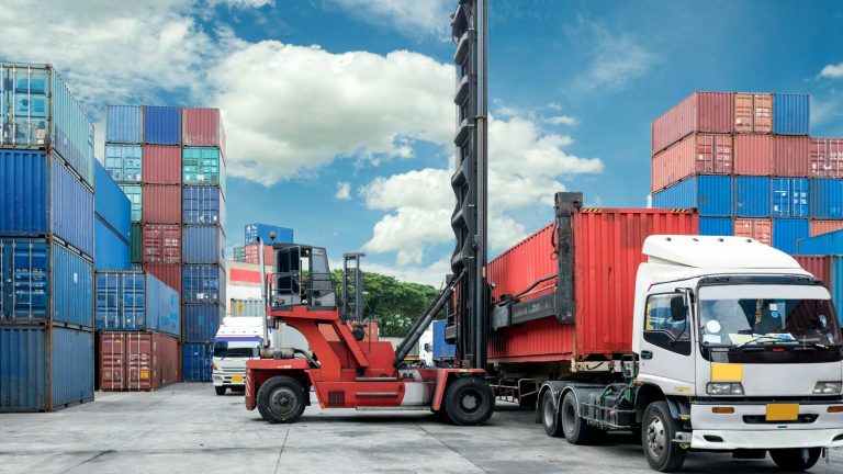 Forklift handling shipping containers at a cargo yard