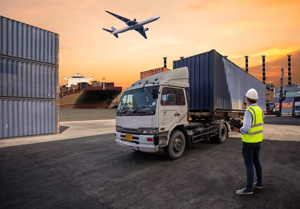 Cargo truck being loaded with a shipping container at a port yard